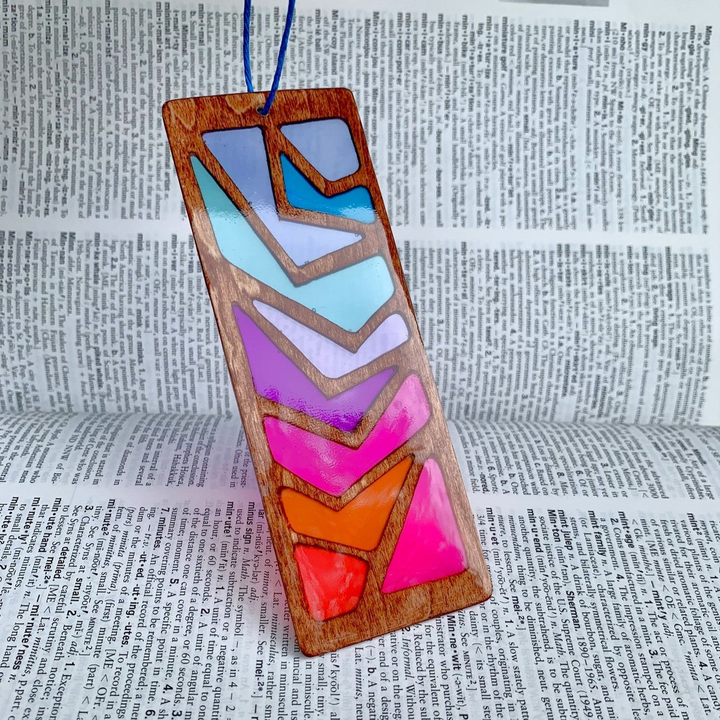 Colorful geometric wooden bookmark on a dictionary background