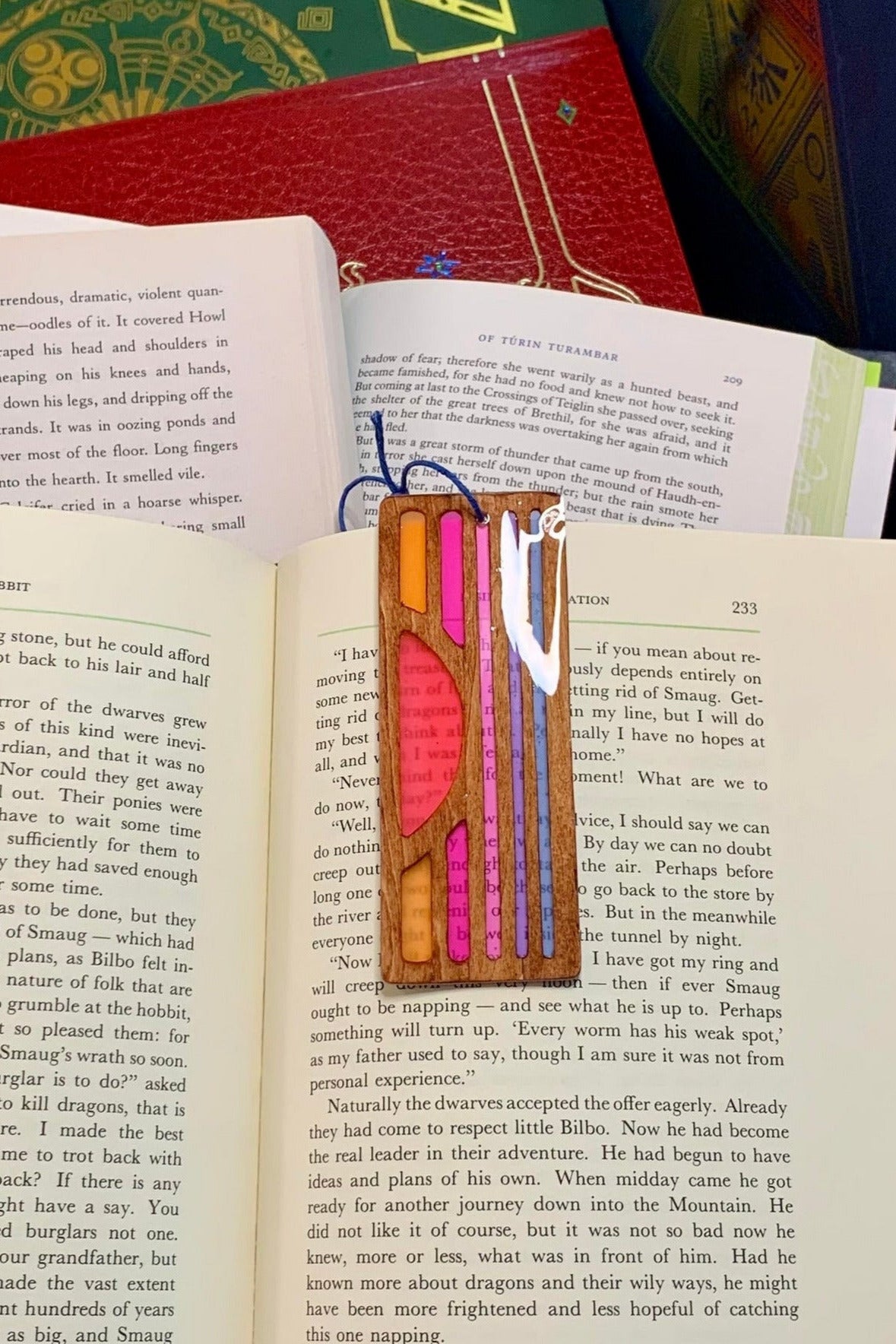 Hand cut wooden bookmark cut into a retro sunset with UV resin translucent colors
