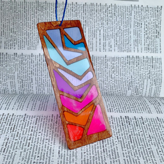 Colorful geometric wooden bookmark on a dictionary background